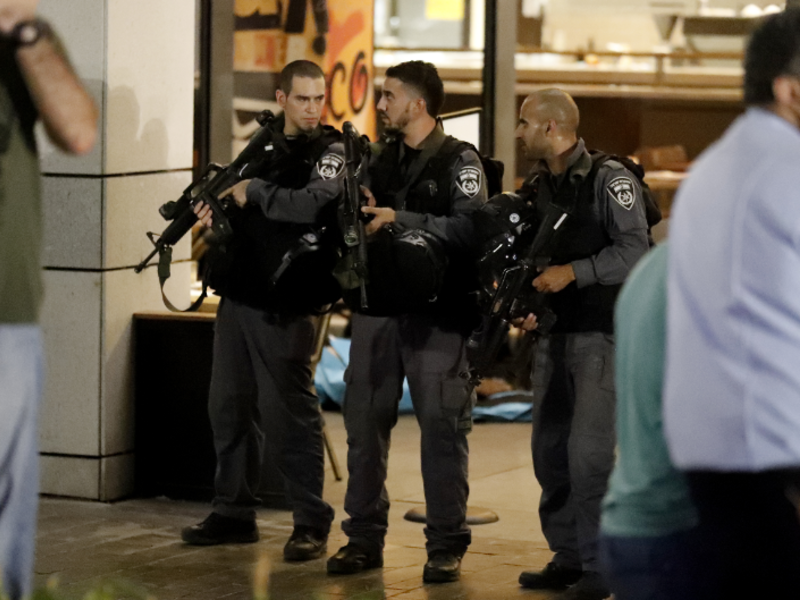 Israeli security forces gather outside the Sarona shopping complex after a shooting attack on June 8, 2016. (AFP/Jack Guez)