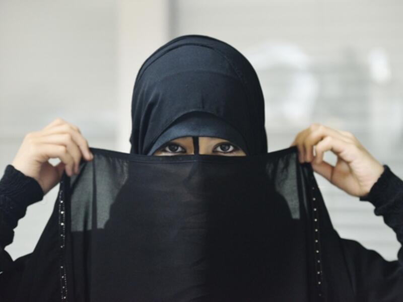 A woman puts on a Niqab, an act now illegal in the Swiss province of Ticino (Shutterstock)