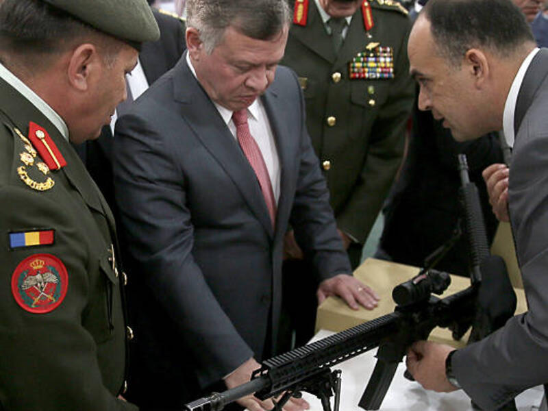 King Abdullah II of Jordan (C) checks a machine gun as he attends the Special Operations Forces Exhibition and Conference (SOFEX) in the Jordanian capital Amman. (AFP/ File Photo)