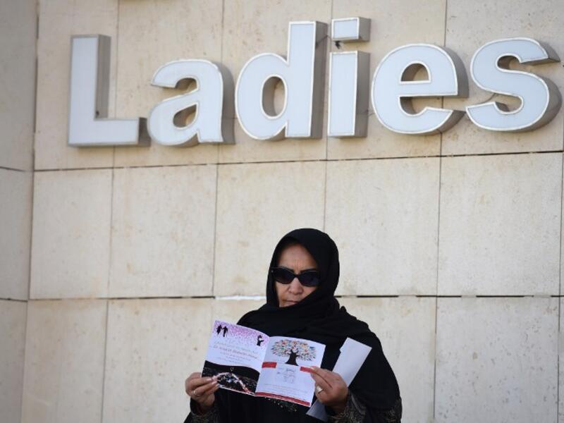 A female candidate stands underneath the "Ladies" voting area sign after casting her ballot. (AFP/Fayez Nureldine)