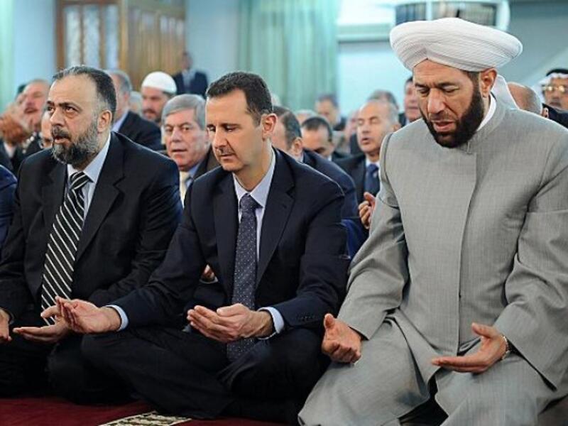 Alawites also different from other Muslims in their prayers, foregoing prostration but folding in songs. They practice “taqiyya”, pretending outwardly to be Sunni Muslim while hiding their real beliefs. Not every Alawi fasts, the hijab is not mandated, and some privately eat pork! (This image of Assad alleges he “prays like a Sunni”.) 
