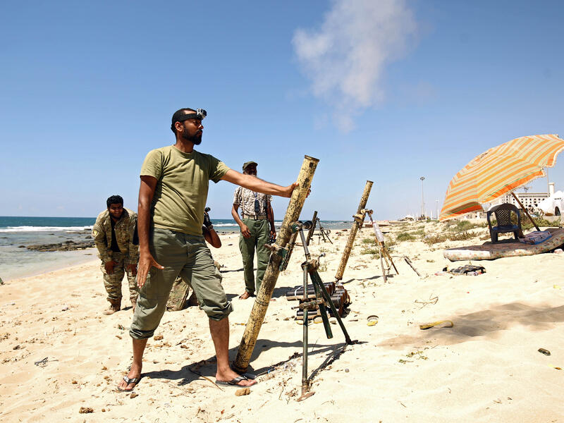 Members of the self-styled Libyan National Army, loyal to the country's east strongman Khalifa Haftar, fire mortar shells during clashes with militants in Benghazi. (AFP) 