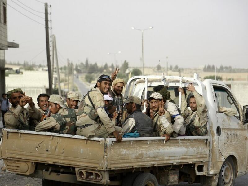 Fighters from Syria's Manbij military council sit on June 15, 2016 in the back of a pickup truck on the outskirts of the northern Syrian town of Manbij. (AFP/Souleiman)