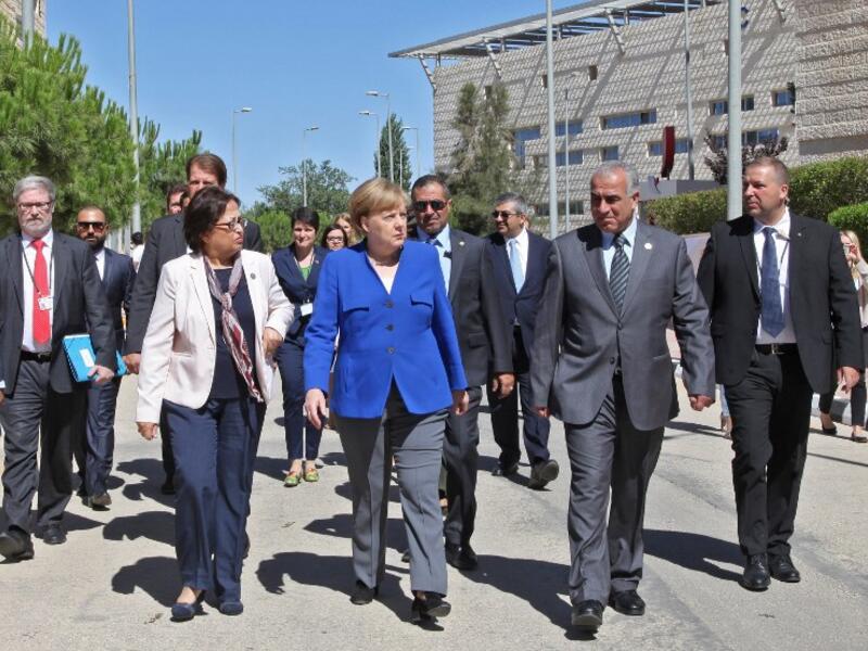 German Chancellor Angela Merkel walks during her Jordan visit in the German-Jordanian University in the Jordan city of Madaba, June 21, 2018. (AFP Ahmad Abdo)