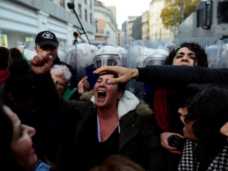 Women's rights activists react during clashes with Turkish riot police as they try to march to Taksim Square to protest against gender violence in Istanbul, on November 25, 2018, on the International Day for the Elimination of Violence against Women. 
Yasin AKGUL / AFP