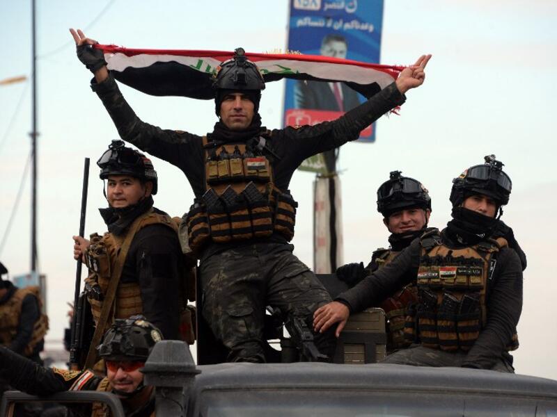 Members of the Iraqi security forces take part in celebrations marking the first anniversary of the country's victory over the Islamic State (IS) group, in the northern Iraqi city of Mosul, on December 10, 2018.
Zaid AL-OBEIDI / AFP