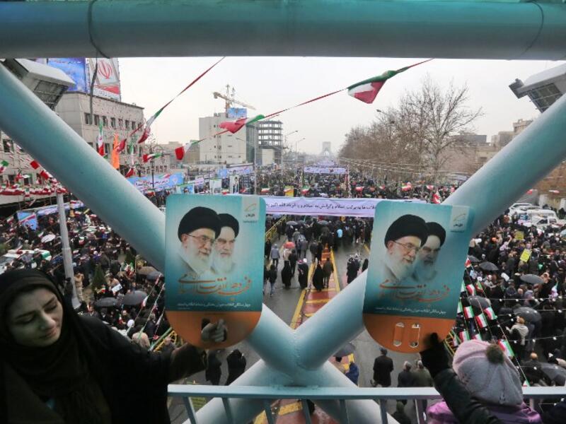 Iranians hold up signs showing portraits of the country's Supreme Leader Ali Khamenei (L) and his predecessor and Islamic Revolution founder Ayatollah Ruhollah Khomeini.
ATTA KENARE / AFP