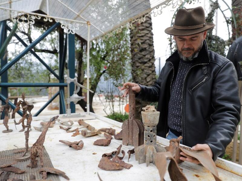 Lebanese Artist Charles Nassar inpsects his sculptures made out of artillery shrapnels in the village of Remhala, south of Beirut, on March 7, 2019.
JOSEPH EID / AFP