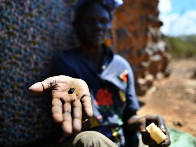 Esther Ewoi, a traditional snake-bite healer, shows the little black stone she uses to suck venom out of a snakebite, as she sits outside her home in Kapkirwok village in Baringo county, on February 21, 2019. 
TONY KARUMBA / AFP