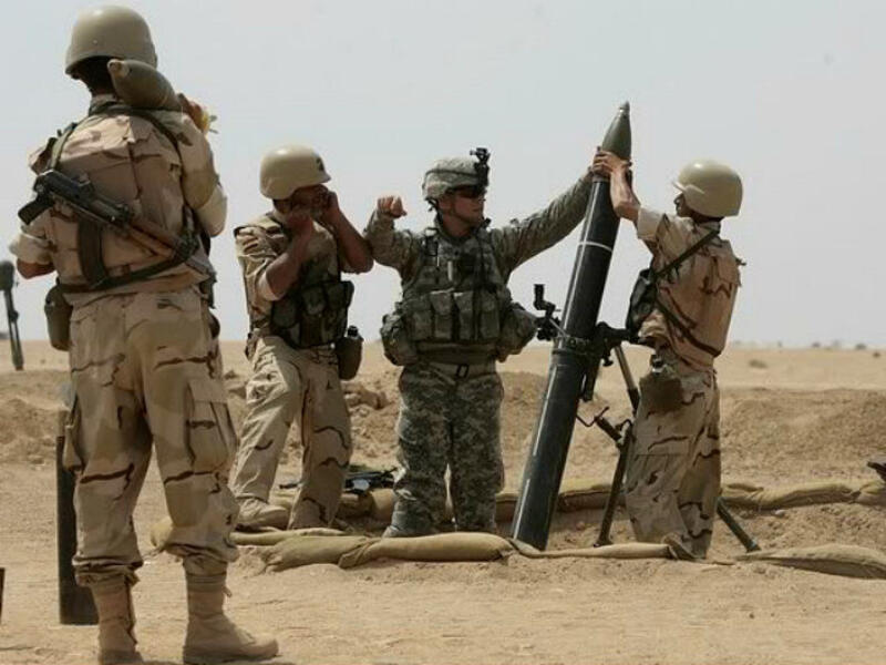 A US military adviser helps soldiers from the 17th Iraqi army brigade load a mortar. (AFP/ File)