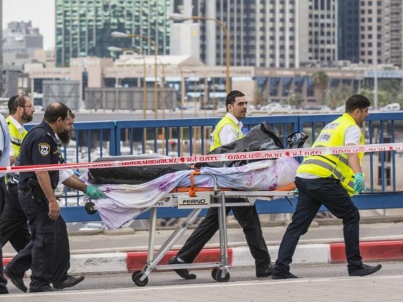 Volunteers remove the body of a Palestinian shot dead after carrying out a stabbing attack. (AFP/File)