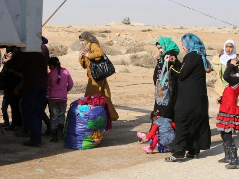 Iraqi women and children who have fled Fallujah wait at an army checkpoint. (AFP/Ahmad al-Rubaye)