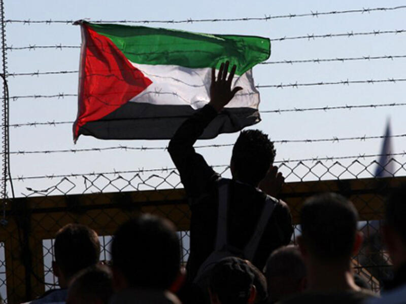 A Palestinian flag is attached to the barbed wires of Israel's Ofer prison in West Bank. (AFP/File)