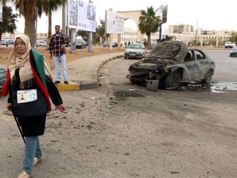 A woman walks near a damaged car after shelling hit a protest rally in Benghazi on May 6, 2016. (AFP/File)
