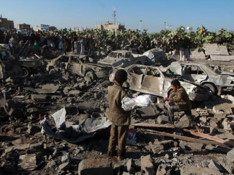 Yemenis stand at the site of a Saudi air strike against Houthi rebels near Sanaa Airport. (AFP/File)  