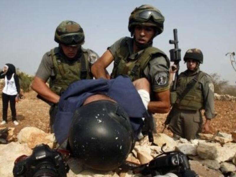 Israeli soldiers detain a Palestinian journalist during a demonstration. (AFP/File)