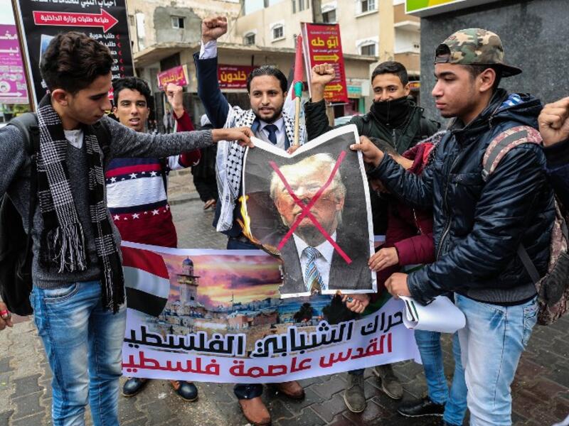 Palestinian protesters prepare to burn a picture of US President Donald Trump in the southern Gaza Strip town of Rafah on December 6, 2017. (Said Khatib/AFP)