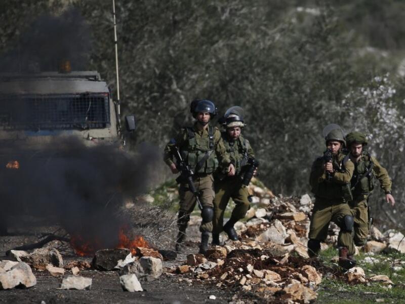 Israeli soldiers keep position during clashes with Palestinian protestors following a weekly demonstration against the expropriation of Palestinian land by Israel in the village of Kfar Qaddum, near Nablus, in the occupied West Bank on February 10, 2017. (AFP/Jaafar Ashtiyeh)