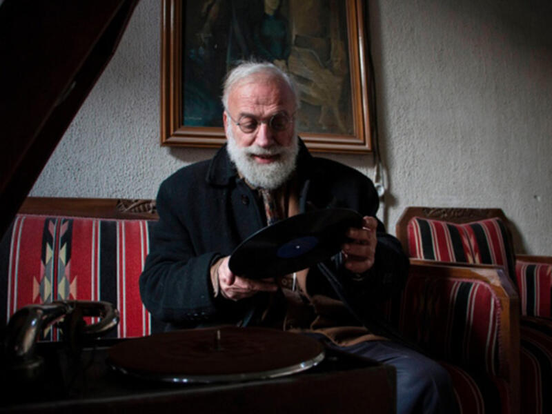Mohammed Anis puts a record on his trusty gramophone at his home in Aleppo. His family gone, his home bombed out, the record player is one of the few things still working - and a main source of joy for him. 