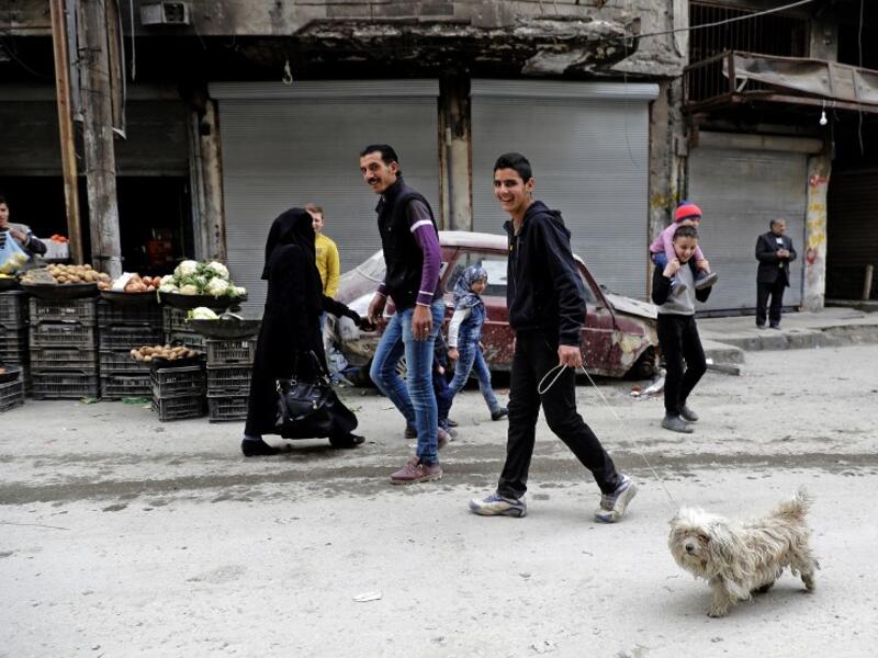 Life going back to normal. A Syrian man walks his dog in the previously rebel-held al-Shaar neighborhood in the northern city of Aleppo on March 10, 2017. 