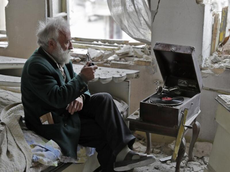 “Anis puffed on his pipe,” the AFP’s Joseph Eid wrote. “He looked out the window and he had a look on his face of a person watching a beautiful sunset. He sat there, puffing on his broken pipe and staring out the window as the music floated over the ruins of his house and the city outside.”  