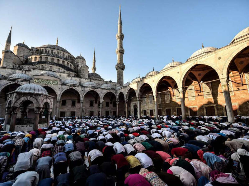 Muslim worshippers gather to perform Eid el-Fitr prayers at the Blue mosque in Istanbul on June 25, 2017. The Blue mosque, while a famous tourist side, is still used for prayers and closes for visitors during praying hours. 