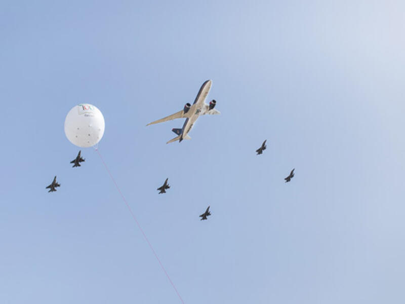 A Royal Jordanian commercial plane flies overhead, flanked by fighter jets from Jordan's air force as part of celebrations marking the centennial of the Great Arab Revolt in Amman.