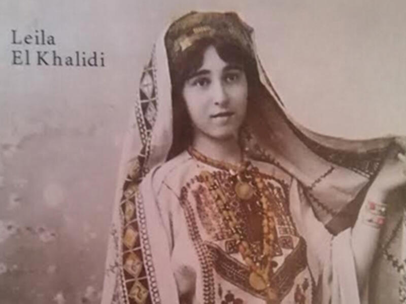 A Palestinian girl wears a traditional embroidered gown and headdress on the book cover of “Art Of Palestinian Embroidery“ by Laila El-Khalidi. (Laila El-Khalid, Saqi Books) 