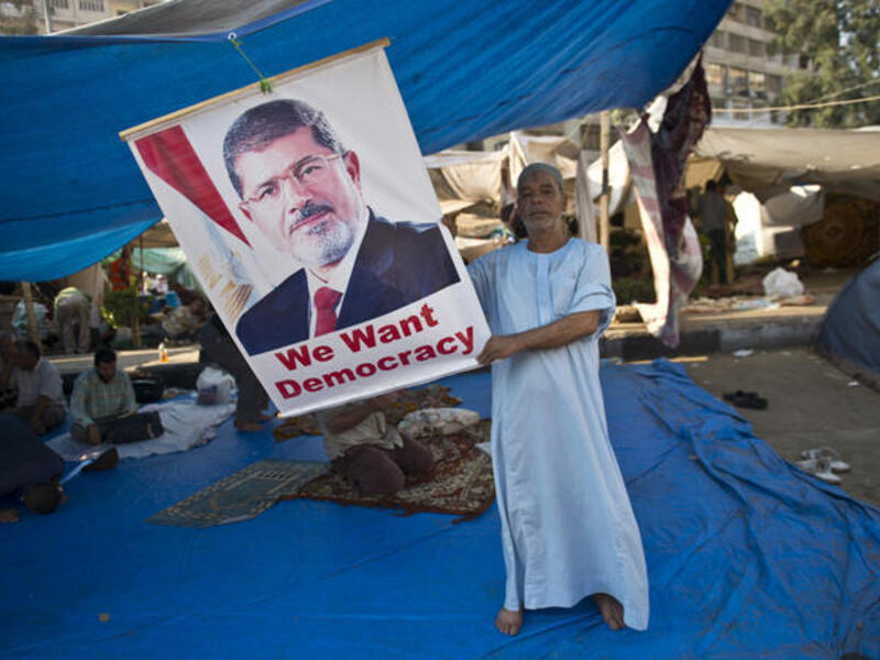 An Egyptian holds a portrait of deposed president Mohamed Morsi during a continiuing sit-in in his support outside Rabaa al-Adawiya mosque in Cairo (AFP/KHALED DESOUKI)