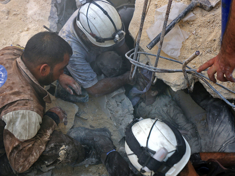 A child is rescued from the remains of an air strike in Aleppo  (AFP/Thaer Mohammed)