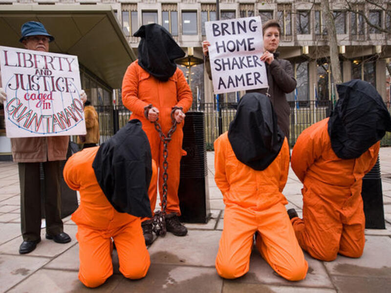 A protestor holds up a sign calling for the release of Shaker Aamer from the US Guantanamo Bay military prison. (AFP/File) 