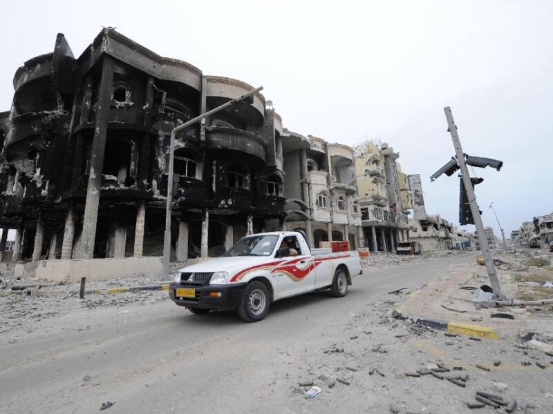 A truck drives through a destroyed neighborhood in Sirte, Libya. (AFP/Philippe Desmazes)