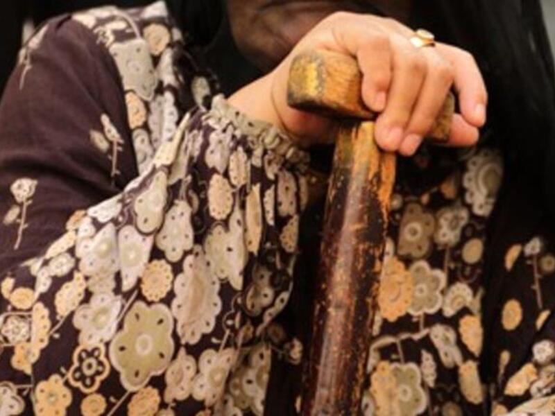 An Egyptian woman holds an election flyer depicting candidate Abdul Moneim Amara as she sits outside a polling station in Cairo's Imbaba neighborhood, as the nation of some 41 million eligible voters goes to the polls.