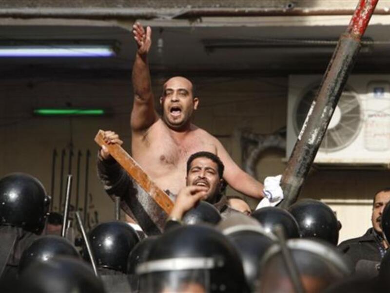 Egyptian Christians face riot police during confrontations outside the Al-Qiddissine church.