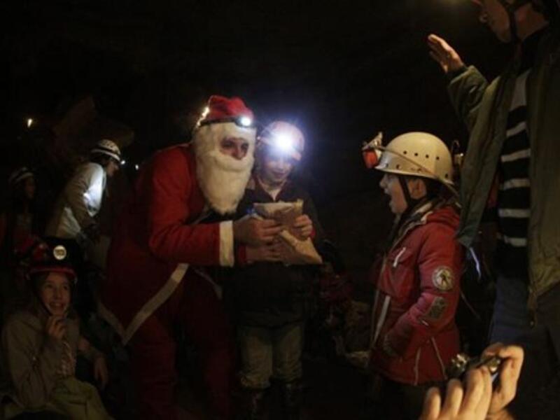 A Lebanese caver from the(ALES) disguised as Santa Claus, distributes gifts to children of the Association members and their comrades as the cavers celebrate with them Christmas inside a cave in the village of Rweiss nearly at 2000 meters above sea level in the Lebanese mountains north of Beirut.