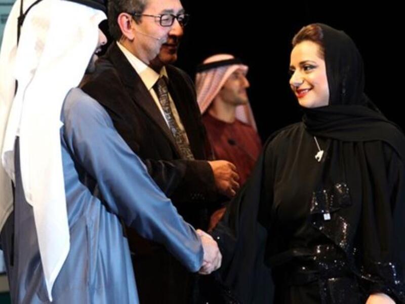 المخرجة الإماراتية نائلة الخاجة تصافح صاحب السمو الشيخ منصور بن محمد بن راشد آل مكتوم.