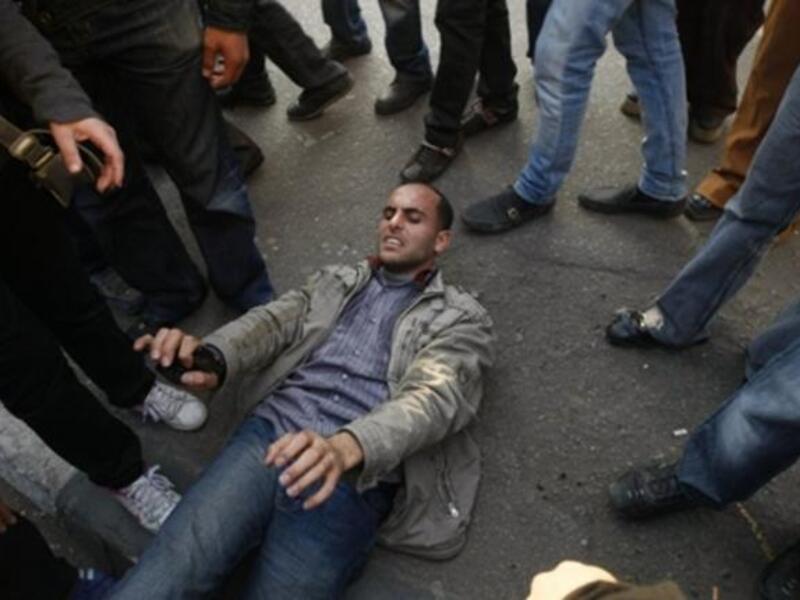A wounded Egyptian demonstrator lies on the ground during clashes with Egyptian police.