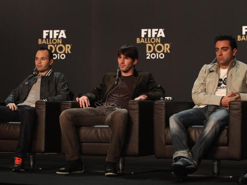 Lionel Messi (C) of Argentina alongside Xavi (R) and Andres Iniesta (L) of Spain during a press conference ahead of the FIFA Ballon d'or Gala.