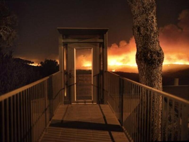 A forest fire rages out of control in front of a residential house  in the hills above the coastal Israeli city of  Haifa.