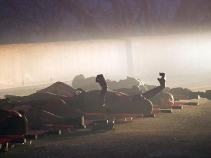 Burnt bodies lie on the ground after a bus was trapped in a huge forest fire that raged out of control near Israel northern city of Haifa