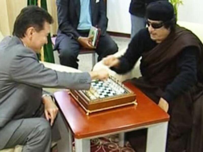 Still playing games with us, Moammar? Always full of surprises: as the world waits for his next move we can count on him to keep it flamboyant and bizarre. Here seen on Libyan state TV in June, the Libyan leader has been playing chess with
the visiting Russian head of the World Chess Federation. 