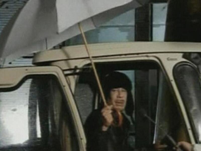 Hiding under the umbrella: Coined the 'umbrella' or 'I'm still in Tripoli' speech, apologizing that he'd love to say more than his 
2 minutes worth but that rain prevented him (as the people amassed
under the showers to register their discontent). It's a good thing he doesn't live in England...