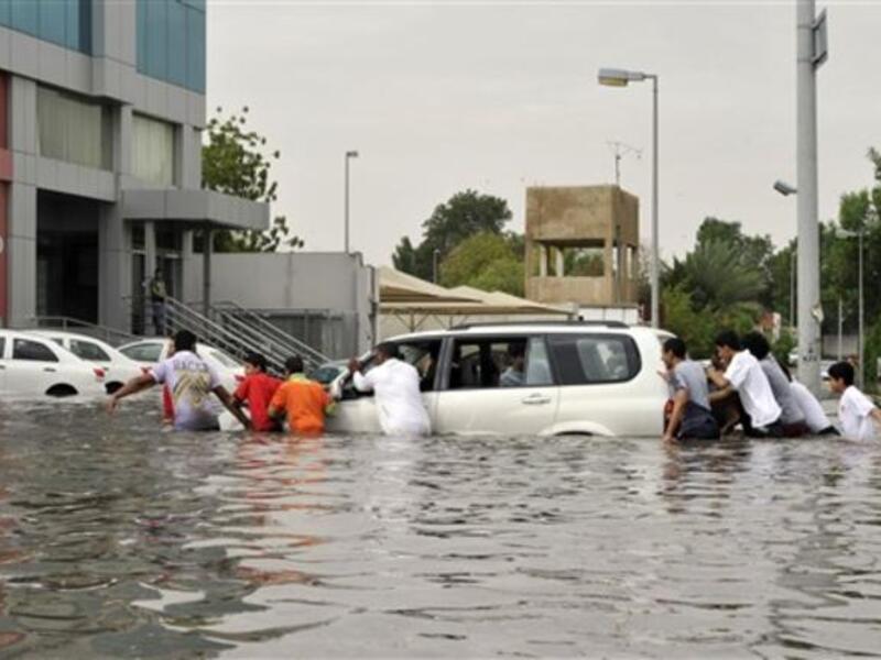 Saudi men keep pushing, doing as what they red sign says "Push to Do" (L).