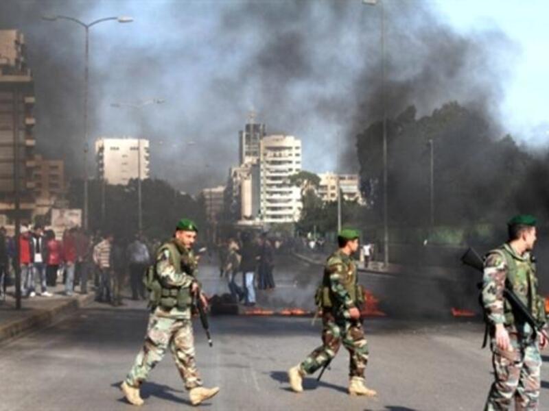 The Lebanese army are seen on the streets as supporters of the Future Movement burn tires in a neighborhood in the capital Beirut during a demonstration in support of the caretaker prime minister Saad Hariri.