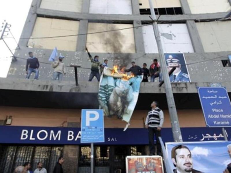 Supporters of the Future Movement torch a poster of Lebanese MP Najib Mikati during a demonstration in support of the caretaker prime minister Saad Hariri in the Sunni bastion coastal city of Tripoli north of Beirut.