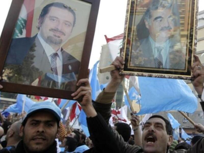 Holding up images of caretaker prime minister Saad Hariri (L) and his late father Rafiq (R) Lebanese supporters of the Future Movement.