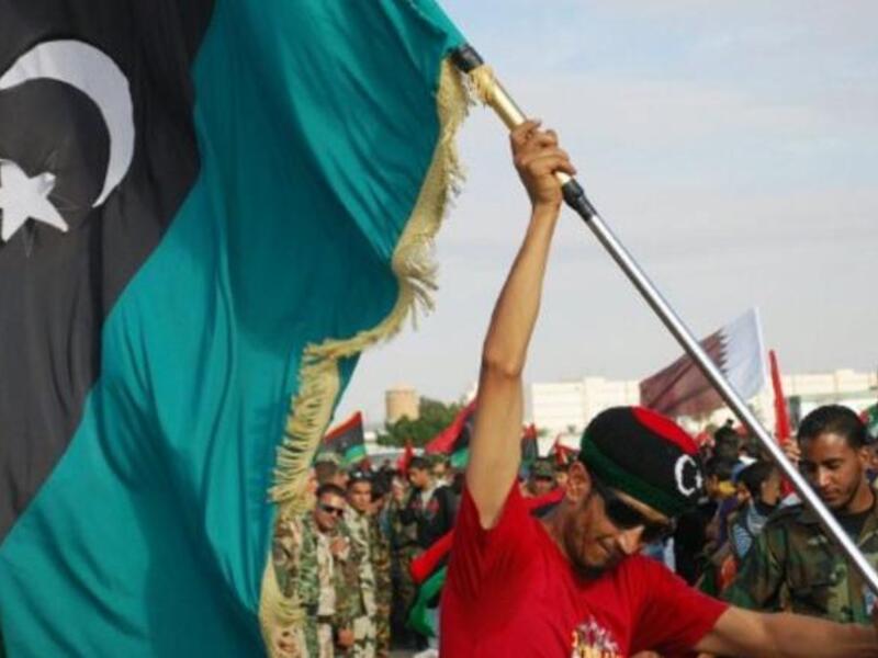 A Libyan man waves his new national flag during a ceremony announcing the liberation for the country in the eastern city of 
Benghazi. The new flag chimes in with the new chapter of hope for Libya. It also promises a return to Islamic values, 
with the reinstatement of rights to marry more than one wife, as well as exclusively Islamic banking.