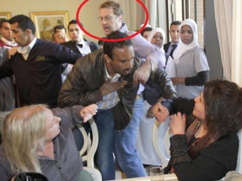 مراسل الفايناشينال تايمز يحاول حماية العبيدي من هجوم الموظفيين الليبيين عليها في مطعم الفندق.