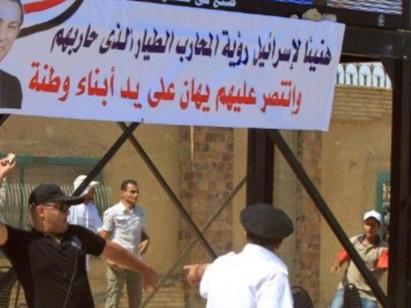مؤيدو مبارك يرفعون لافتات التأييد أثناء محاكمته