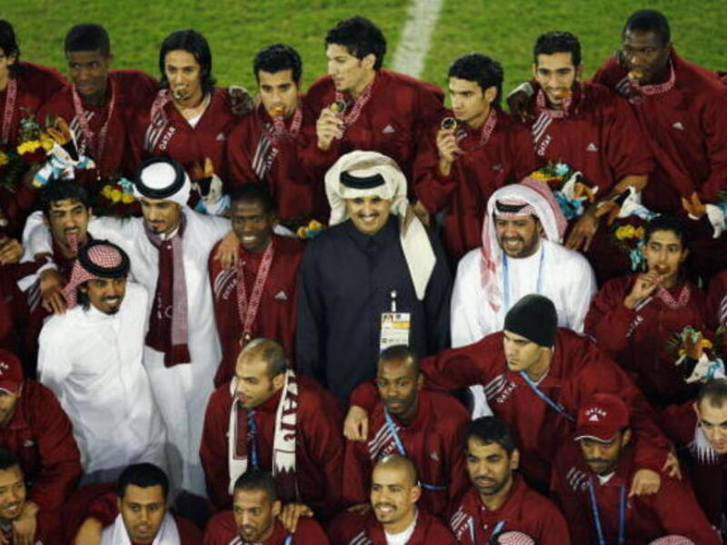 Sheikh Tamim Bin Hamad Al-Thani celebrates with the Qatar team after the gold medal match between Qatar and Iraq (Getty)